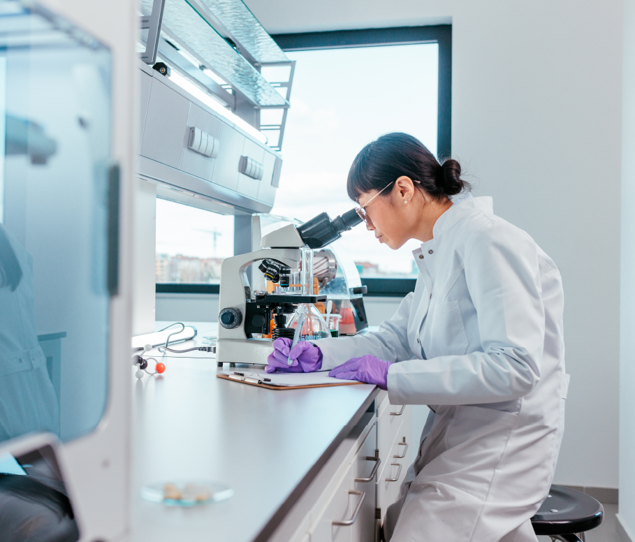 A scientist in a lab using a microscope.